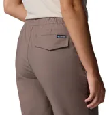 Pantalón jogger color marrón, de corte cónico con puños elásticos en los tobillos, cintura elástica y bolsillos frontales tipo parche.