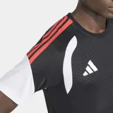 Remera deportiva Adidas de la línea Tiro 26 Competition, diseñada para entrenamiento de fútbol. Presenta un diseño con panel frontal texturizado, inserciones de malla para ventilación y tecnología Climacool para gestión de la humedad. Cuenta con cuello redondo y detalles de las tres rayas en los hombros.