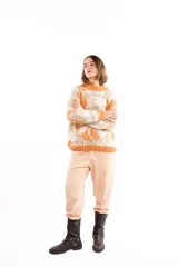 Buzo de tejido jacquard con diseño de formas orgánicas en tonos naranja y beige, de calce relajado, cuello alto y terminaciones tejidas en rib.