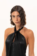 Vestido midi de satén color negro, con escote halter cruzado y ruedo terminado en flecos largos.