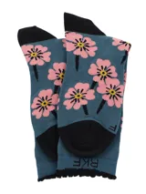 Medias de caña media color turquesa con estampado de flores rosadas, talón y puntera en color negro, y borde superior con detalle de ondas.