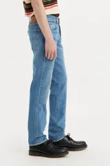 Jean de corte slim fit con tiro medio, confeccionado en denim de tono azul medio con acabado desgastado.