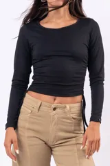 Remera de manga larga color marrón, con cuello redondo y diseño ajustado al cuerpo. Presenta detalles de frunces laterales con cordones ajustables en la parte inferior.