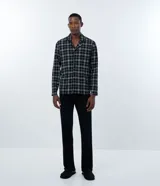 Camisa de pijama de manga larga con cuello camisero y cierre frontal de botones. Presenta un estampado de cuadros y está confeccionada en tejido de punto de algodón.