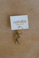Aro tipo argolla con dije colgante en forma de letra, fabricado en bronce. Se vende por unidad.