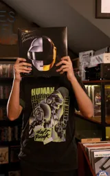 Remera de algodón premium con calce oversize, cuello redondo y mangas cortas. Presenta un estampado gráfico frontal con temática de Daft Punk en tonos verdes y negros.