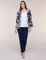 Cardigan confeccionado en tul semitransparente con estampado floral, de frente abierto y mangas 3/4, acompañado por una blusa interior blanca con detalles de tachas en el escote.