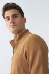 Campera negra de algodón con cierre completo, cuello alto, bolsillos laterales, puños y logo bordado en el pecho.