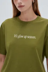 Remera de manga corta negra, con cuello redondo y estampado de texto blanco en el pecho.
