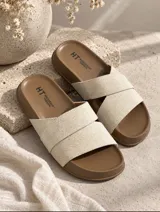 Sandalias planas color marrón con tiras cruzadas y suela moldeada.