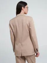 Blazer color beige con solapas y cierre con un botón.