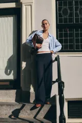 Pantalón de tiro alto color gris oscuro con finas rayas verticales blancas (pinstripe). Posee pernera recta y ancha, y doble cintura elástica con tejido combinado.