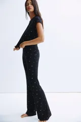 Pijama de dos piezas confeccionado en punto acanalado de modal. Incluye una remera de cuello redondo con mangas cortas terminadas en ribete de encaje y un pantalón con cintura elástica y corte levemente acampanado.