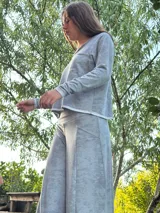 Conjunto color mostaza compuesto por un pantalón palazzo de corte evasé y una remera de manga larga con escote en V y bolsillo en el pecho.