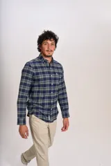 Camisa de manga larga confeccionada en tejido de franela con estampado de cuadros en tonos azul marino y verde. Presenta cuello abotonado, cierre frontal con botones y un bolsillo en el pecho con el logo bordado de la marca.