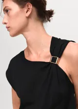 Chaleco de punto fino negro con cuello redondo, manga corta y detalle metálico en el hombro.