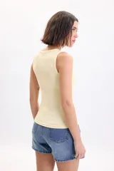 Musculosa de rib color amarillo con escote redondo y diseño ajustado.