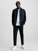 Camisa negra de popelina con corte relaxed, cierre frontal con botones, mangas largas y dos bolsillos con solapa en el pecho.