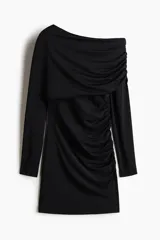 Vestido corto entallado de punto elástico, con diseño asimétrico de un solo hombro y manga larga. Presenta una capa superior drapeada y costuras fruncidas laterales que crean un efecto de pliegues en toda la prenda.