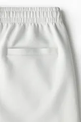 Short de felpa interlock, color gris claro, con cintura elástica con cordón oculto, bolsillos laterales y corte relajado.