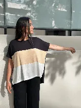 Remera de corte amplio con mangas cortas y diseño a bloques de color: negro en la parte superior, marrón anaranjado en el centro y blanco en la parte inferior.