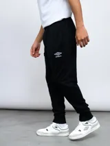 Pantalón deportivo Umbro negro con puños elásticos en los tobillos y logo Umbro blanco bordado en el muslo izquierdo.