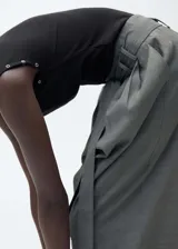 Camiseta de canalé color negro, con cuello redondo y diseño sin mangas. Presenta detalles de ojales metálicos en los hombros.