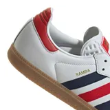 Championes Adidas modelo Samba de color blanco con detalles en rojo, azul marino y gris. Cuenta con diseño clásico de la marca, tres tiras laterales, puntera de gamuza gris y suela de goma.
