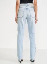 Pantalón de jean celeste con roturas en las rodillas, tiro alto y corte recto.