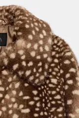 Cazadora de Zara con efecto pelo, diseño de cuello solapa y manga larga. Presenta un estampado animal print tipo cervatillo, bolsillos delanteros y cierre frontal con ganchos metálicos.