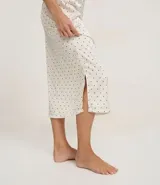 Camisón largo de satén con estampado de lunares, breteles finos ajustables y detalle de encaje negro en el escote.