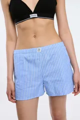 Short de popelina de algodón con estampado de rayas verticales celestes y blancas, cintura elastizada y bolsillos laterales.