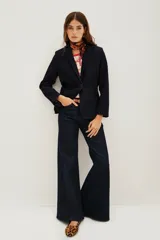 Saco sastrero de denim azul oscuro con costuras a contratono, combinación de forrería en cuerpo y mangas. Tiene botones a tono personalizados en cruce y mangas.