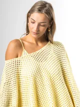 Sweater de tejido en red color amarillo mantequilla, con diseño oversize y amplio, mangas largas y caída holgada ideal para superposiciones.