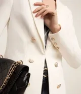 Blazer femenino de sastrería confeccionado en punto roma, con cuello solapa, cierre frontal con botones decorativos y diseño estructurado.