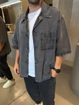 Camisa de jean con lavado gris, corte boxy, manga corta, cuello clásico y bolsillo frontal en el pecho.