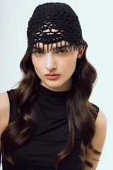 Gorro negro tejido a crochet de diseño artesanal con trama calada y flecos de mostacillas colgantes en el borde frontal.