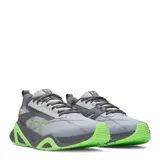Championes de entrenamiento Under Armour modelo Charged Commit Tr 5, color gris con detalles en verde neón. Presentan una estructura robusta con entresuela Charged Cushioning para mayor amortiguación y suela de goma con diseño de alta tracción.