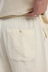Bermuda de caída suelta con cintura elastizada y cordón regulable, confeccionada en tejido texturado negro.