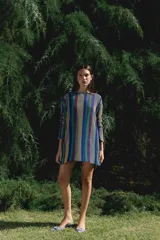 Minivestido de tejido de punto a rayas verticales en tonos marrón, ocre y dorado con lurex. De corte holgado y manga larga.