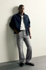 Jeans flare fit de denim de algodón en color celeste con lavado efecto desgastado. Presentan diseño de cinco bolsillos, tiro medio, cierre frontal con cremallera y botón, y bajo con acabado irregular.