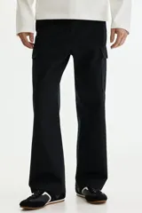 Pantalón cargo negro de sarga de algodón, con bolsillos laterales con solapa en las perneras y corte relajado.