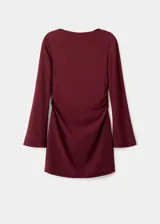 Vestido corto entallado de color bordó, con cuello barco y mangas largas. Presenta detalles de fruncidos laterales en la cintura.