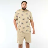 Remera de manga corta y cuello redondo en color beige con estampado integral de palmeras en tono azul oscuro.