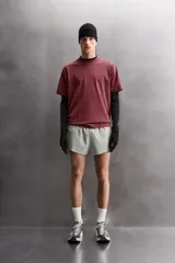 Camiseta de entrenamiento de ajuste relajado, color vino tinto, confeccionada en tejido de peso medio con mezcla de algodón. Presenta cuello redondo con acabado en vivo doble y manga corta.