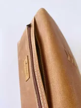 Billetera de cuero color camel con sistema de cierre con broche y monedero externo.