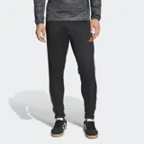 Pantalón de entrenamiento Adidas Tiro25 Essentials, color negro con logo de la marca bordado en naranja. Presenta un ajuste aerodinámico, cintura elástica con cordón y tecnología Aeroready para control de humedad.