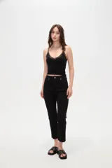 Pantalón jean de tiro alto y corte recto, color blanco, con bolsillos laterales y traseros, y terminación desmechada en los tobillos.