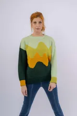 Sweater de lana merino verde con diseño de paisaje abstracto en tonos verde claro, amarillo y naranja.