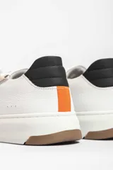 Championes Urban Haus modelo Lyon, de cuero blanco con detalles en color caramelo y beige. Presentan una suela gruesa blanca y logo de la marca en el lateral.